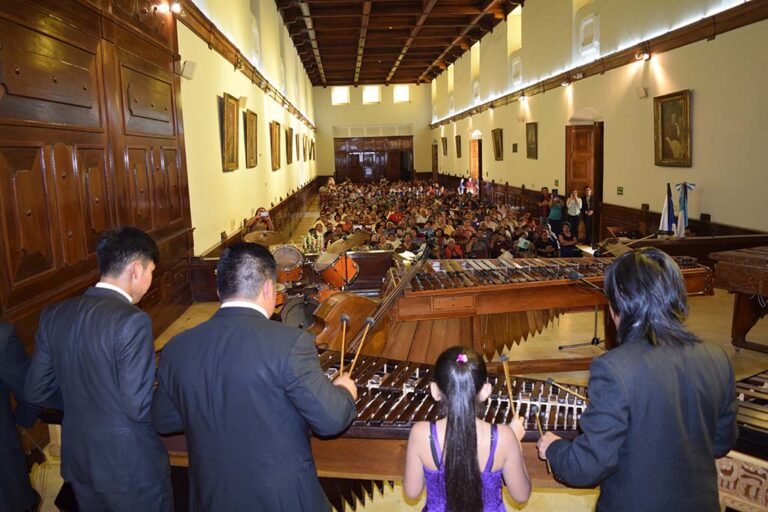 Concierto de Marimba en el Salón Mayor del MUSAC como parte del programa permanente de exaltación a la marimba. Se aprecia el recinto con lleno total de público amante de la música de marimba.